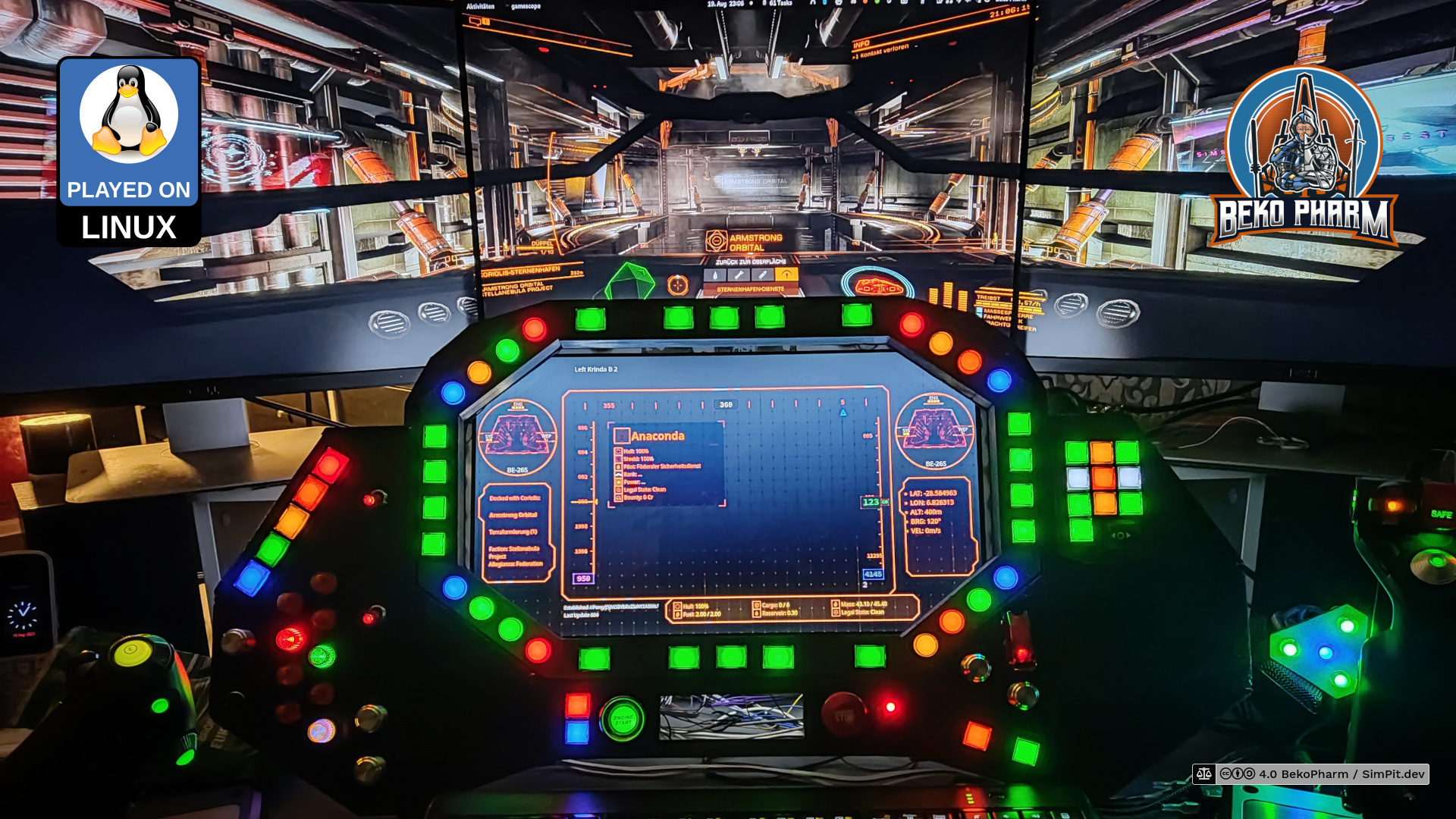 Three monitors form a wall around a box that embeds a fourth monitor, many buttons and switches in various colours are also implemented. Some LED display the status of a spaceship. The computer game that is played with this contraption is Elite Dangerous Odyssey
