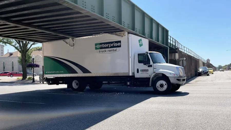 Enterprise rental truck stuck under a bridge