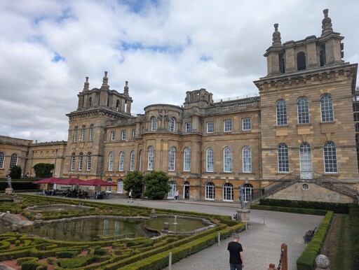 view of neo classical English palace with view of a garden with fountain 