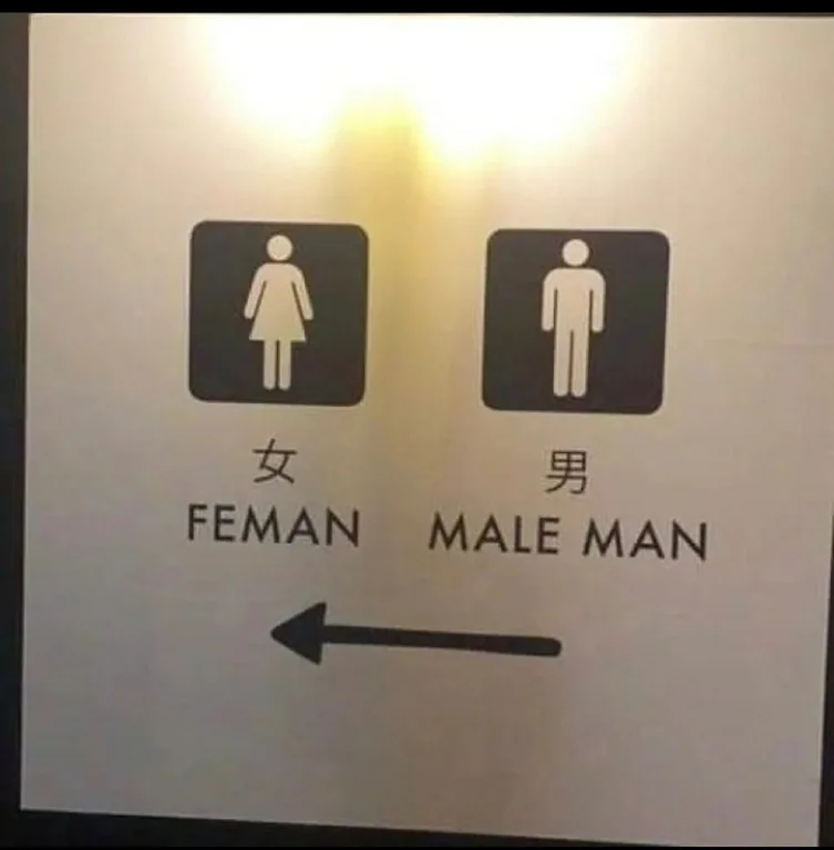 photo of a sign showing genders. FEMAN and MALE MAN are written under the female and male icons respectively.