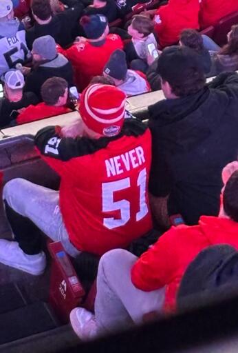 person wearing a red hockey jersey that says never 51