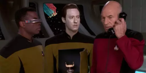 image from Star Trek The Next Generation showing Data's chest opened up and a phone in side. Capt picard is talking on the phone while Geordi looks on. In the background are the two Martian Muppets from Sesame street poking their pink and blue heads through the glass of the star ship. 