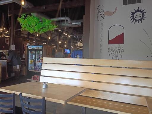 Tables at a bar. A mural on the wall says "Upland"