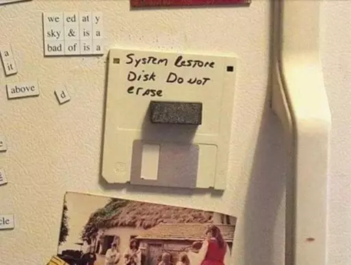 Picture of a floppy disk attached to a fridge door with a magnet labeled: "System restore disk do not erase"