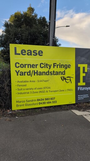 a large real estate sign reading 'Lease: Corner City Fringe Yard / Handstand [sic]'
