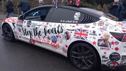 Picture of a car with various decals of right wing politicians, slogans and Union Jacks littered across it. The Jocker is also has several appearances.